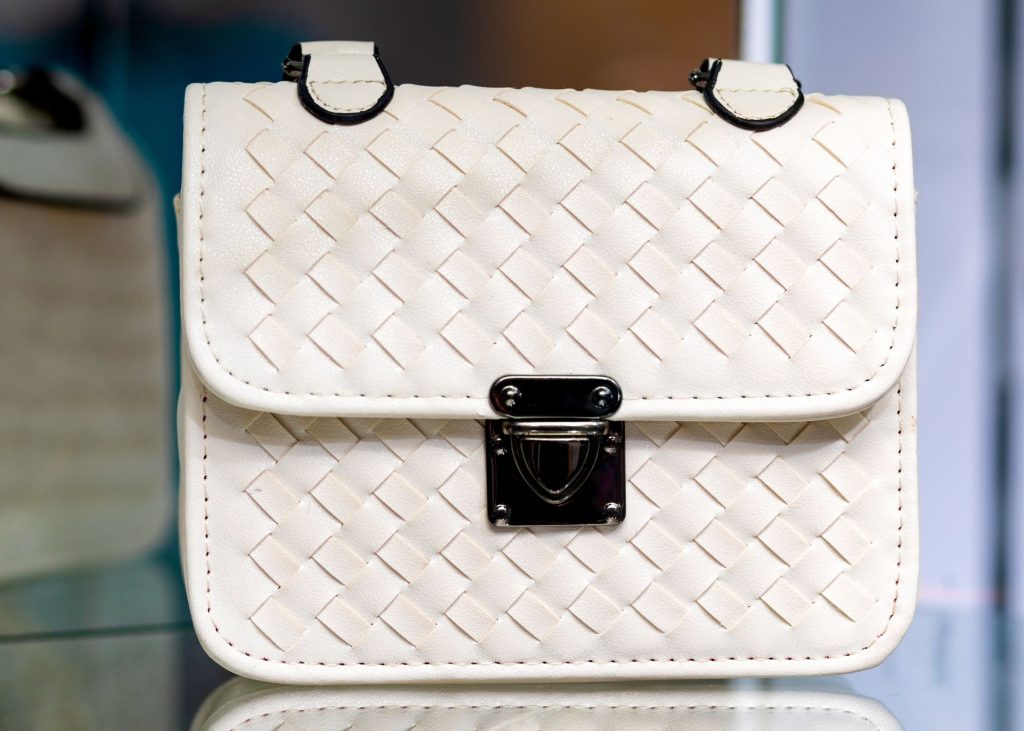 a white purse on a glass table