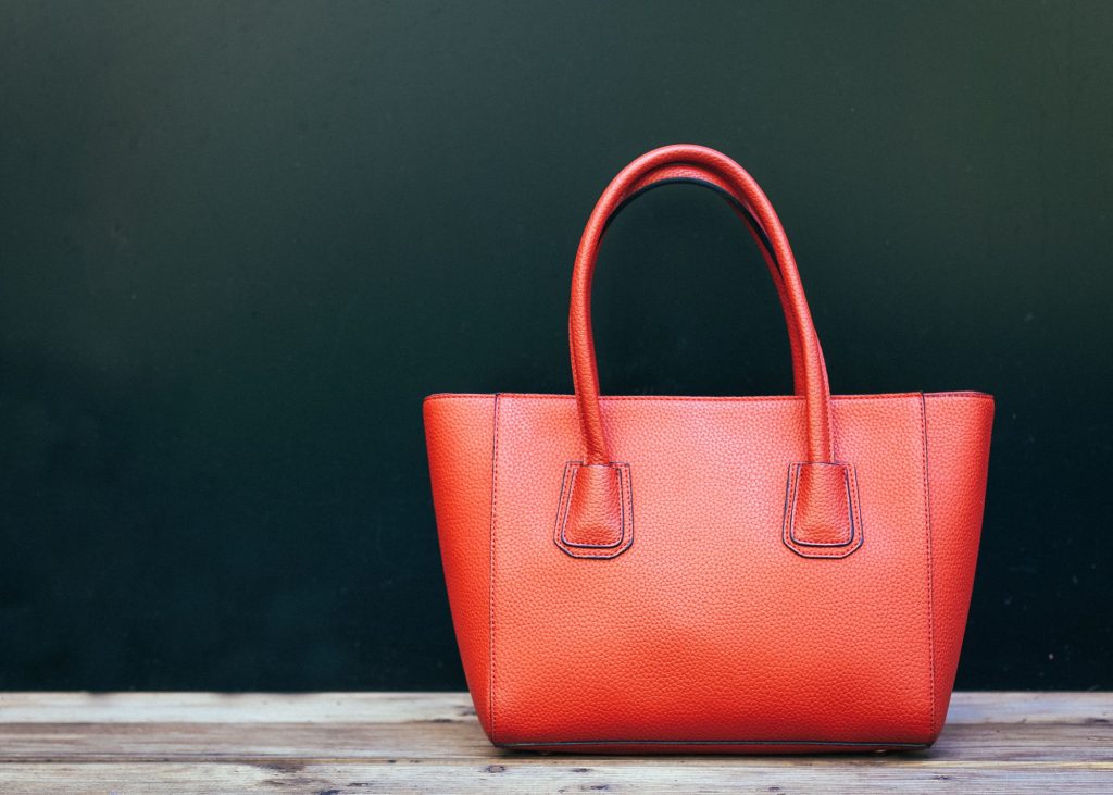 a red purse on a wood surface